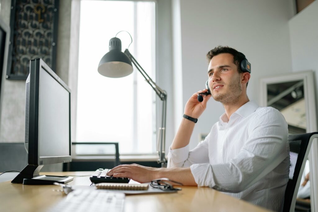 pexels-photo-8867431-8867431 Male call center agent with headset working at desk, providing excellent customer service.